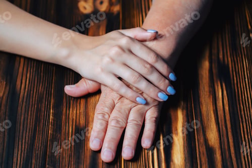Preview: Hands of grandmother and granddaughter on table. Love, family concept