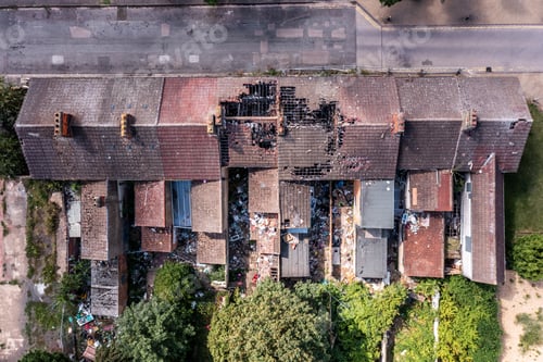 Preview: Aerial view directly above the roof of derelict terraced houses after a house fire