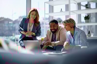 Preview: Happy entrepreneurs cooperating while working on a computer during business meeting in the office.