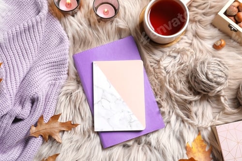Preview: Flat lay composition with notebooks, cup of tea and warm clothes on fuzzy rug