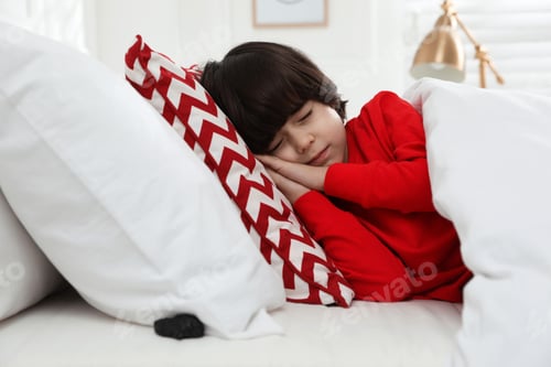 Preview: Cute little boy sleeping in bed, piece of coal under pillow. Saint Nicholas day tradition