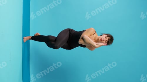 Preview: Vertical video: Fit woman doing balance exercise after workout activity