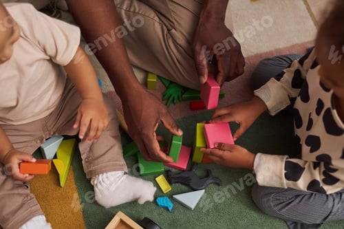Preview: Top view Black father with two children playing with wooden toys together