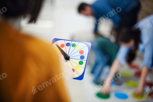 Preview: kids with father and mother playing twister game at home. Family activity
