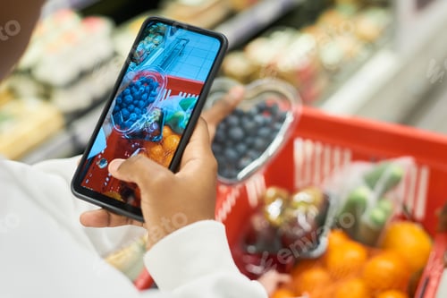 Preview: Hand of young black woman taking photo of packed blueberries on smartphone
