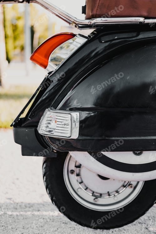 Preview: Vertical close up picture of retro black motorbike's wheel.
