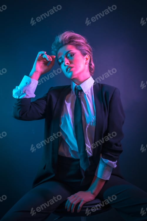 Preview: A sexy young blonde hair female in a black suit posing in studio