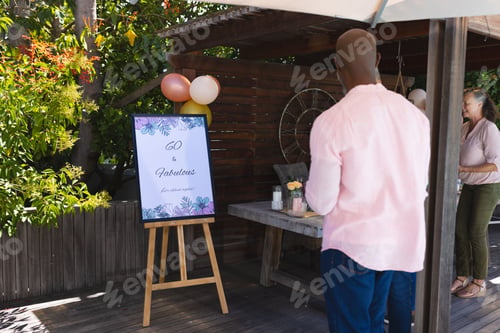 Preview: Celebrating 60th birthday, African American man admiring festive outdoor decorations