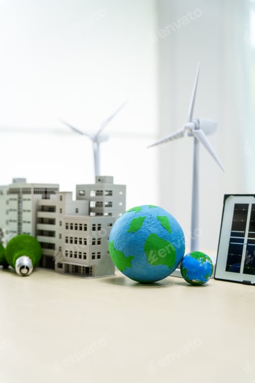 Preview: A white desk displays a model of an electric car, a green light bulb, and solar cells. net zero