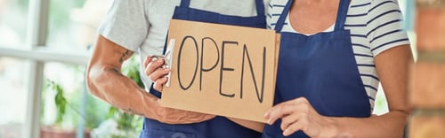 Preview: Middle aged caucasian owners of shop with open board