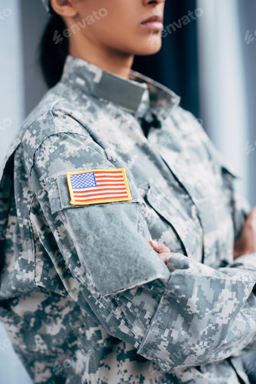 Preview: cropped view of african american female soldier in military uniform with usa flag emblem
