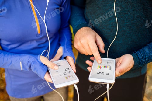 Preview: Unrecognizable running couple with smart phones and earphones
