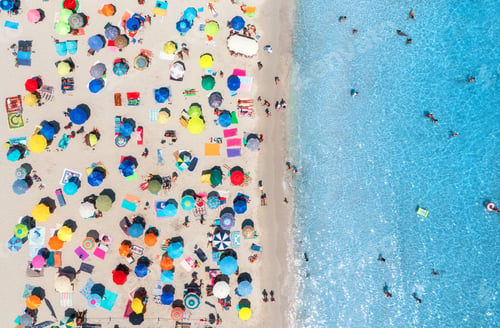 Preview: Aerial view of colorful umbrellas on sandy beach, blue sea