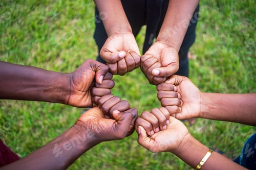 Preview: Teamwork concept with different skin color people touching their fists