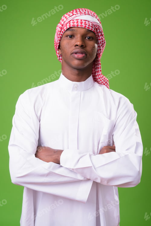 Preview: Young African man wearing traditional Muslim clothes against gre