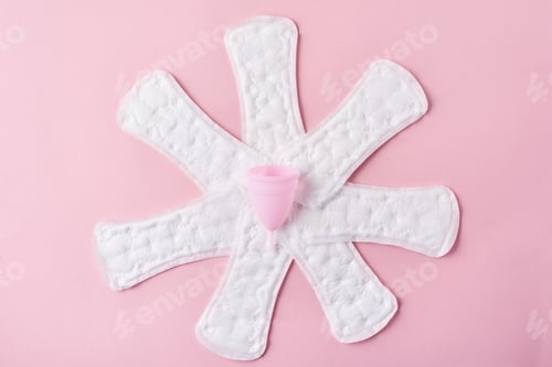 Preview: Sanitary pads and menstrual cup on a pink background