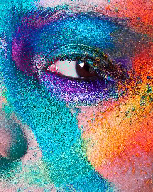 Preview: Studio portrait of young woman's face with multi coloured powder eye shadow, close up