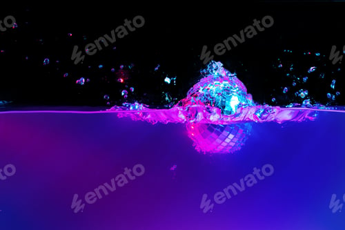 Preview: Disco ball falling into the water with a splash against black backgorund, neon light
