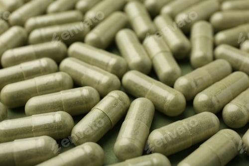 Preview: Many vitamin capsules on olive background, closeup