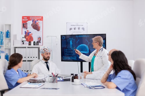 Preview: Specialist neurologist senior woman pointing brain radiography discussing sickness expertise