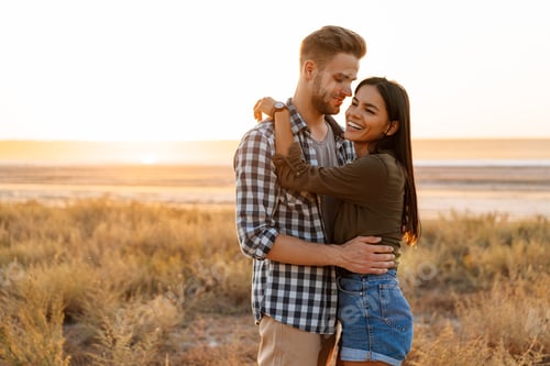 Preview: Romantic happy couple hugging and smiling while strolling on nature