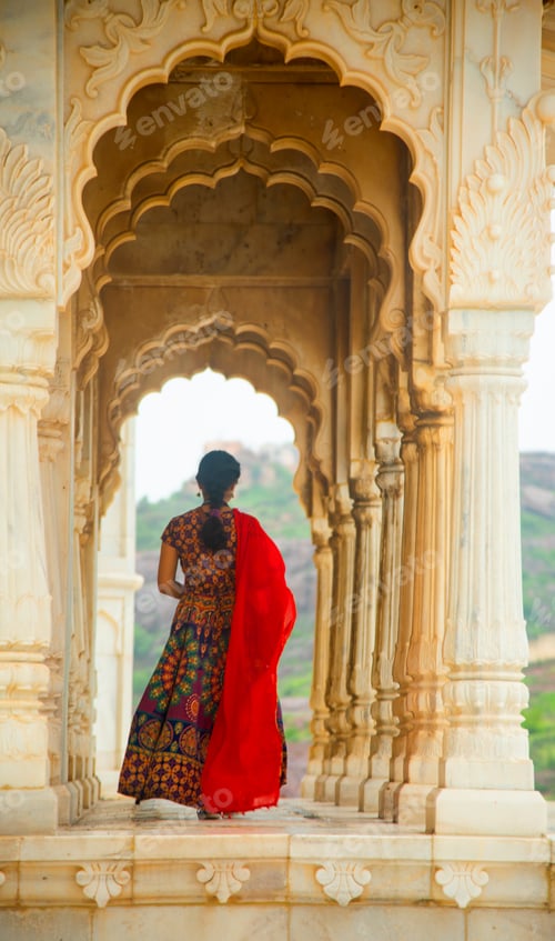 Preview: Indian woman standing between arches and Pillars.