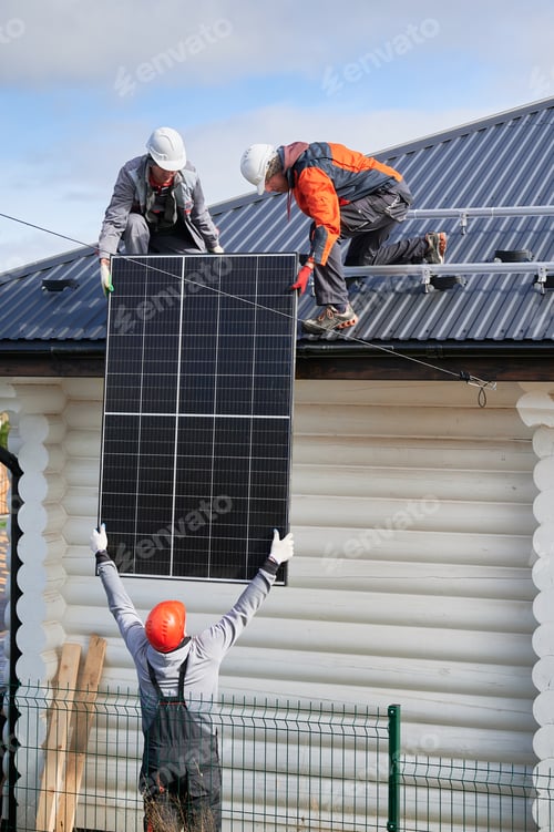 Preview: Professional technicians lifting solar panels on a roof of house