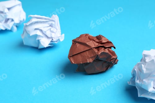 Preview: Stop racism. Crumpled paper pieces of different colors on light blue background, closeup