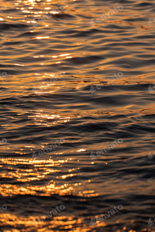 Preview: Ripple sea ocean water surface with golden sunset light. Sea wave close up