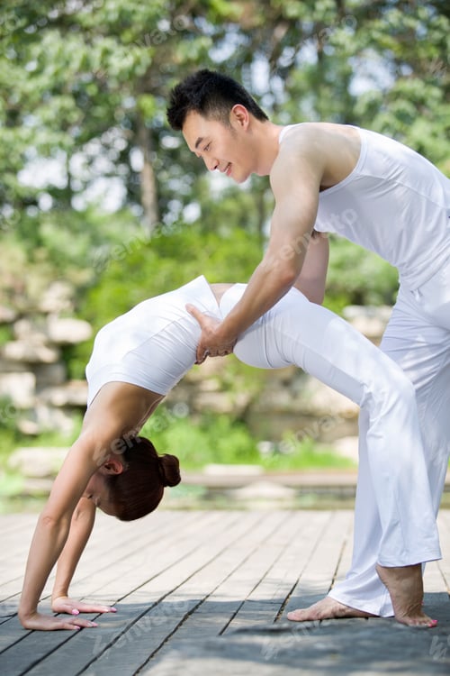 Preview: Young man teaching woman yoga