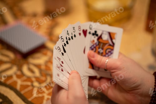 Preview: Selective focus of a hand of playing cards held by a person with a blurry background