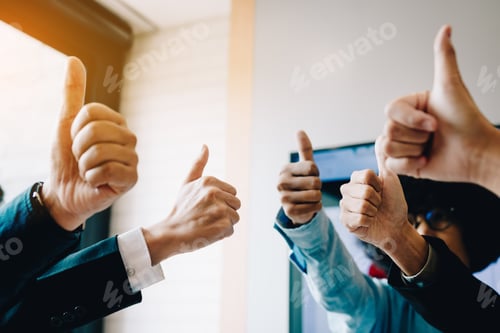 Preview: Group of unrecognizable business people pulling thumbs up in office room.