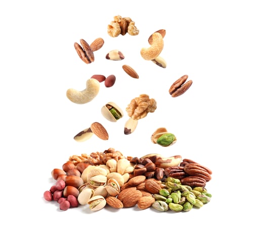 Preview: Different nuts falling into pile on white background