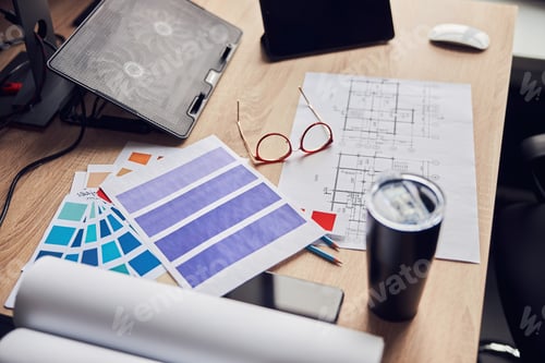 Preview: Close up shot of glasses, architectural blueprint with papers and color samples, thermos flask on