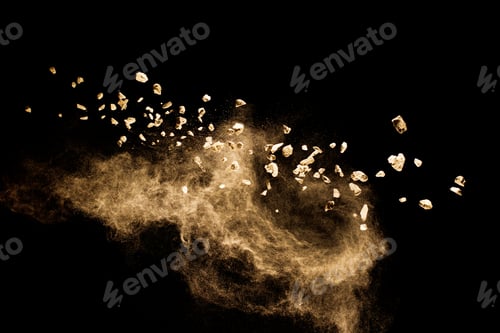 Preview: Split debris of stone exploding with brown powder against black background.