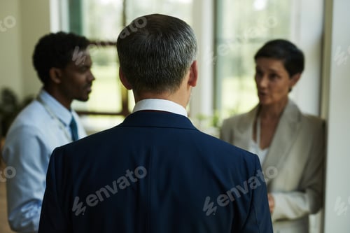 Preview: Middle Aged Caucasian Man Listening to Colleagues in Office Hallway