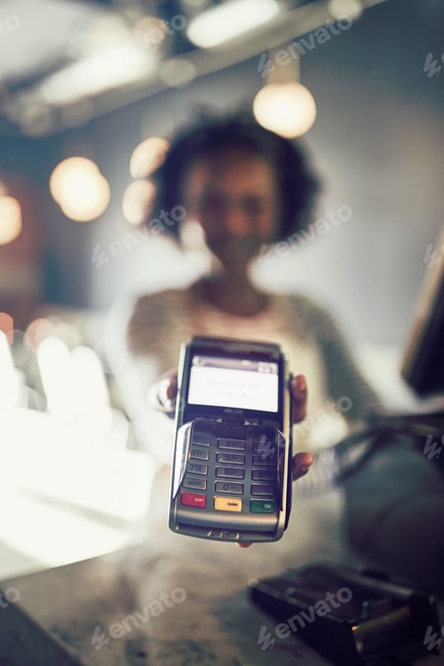 Preview: African waitress holding an electronic card machine in a restaurant