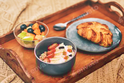 Preview: Cropped shot of a neatly laid out breakfast arranged on a wooden tray and served in bed at home