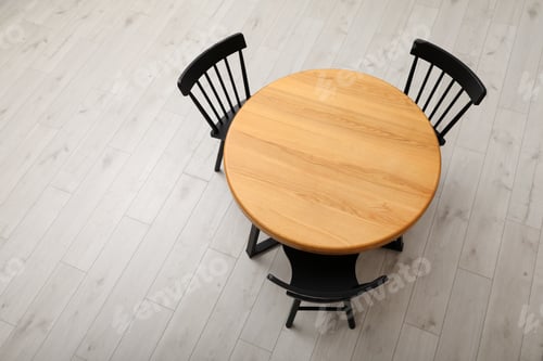 Preview: Stylish round table with black chairs on floor, above view
