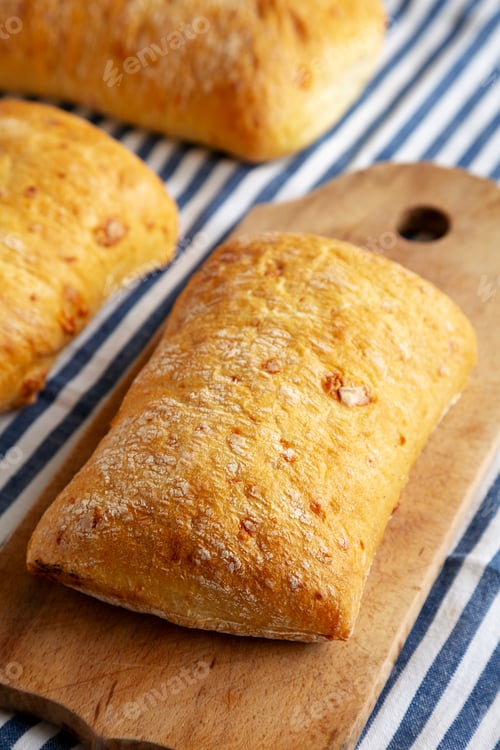 Preview: Homemade Cheese Ciabatta Bread on a Wooden Board, side view.