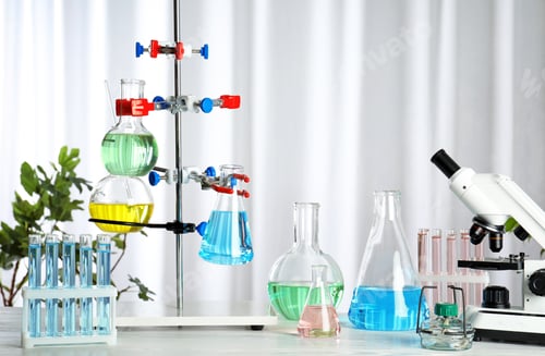 Preview: Laboratory glassware and microscope on table indoors. Chemistry concept