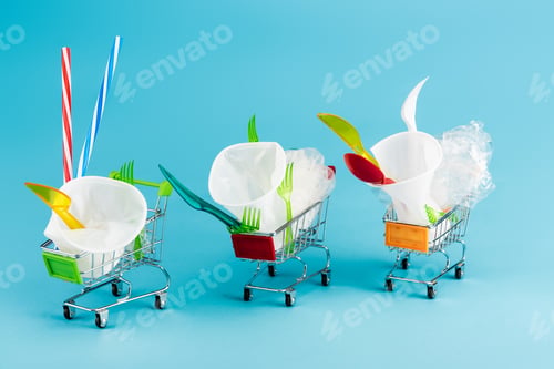 Preview: disposable plastic objects in small shopping carts on blue background