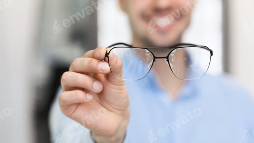 Preview: Closeup portrait of young man showing spectacles
