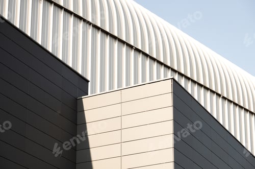 Preview: Outside view of building with metal walls and arched roof of light grey color