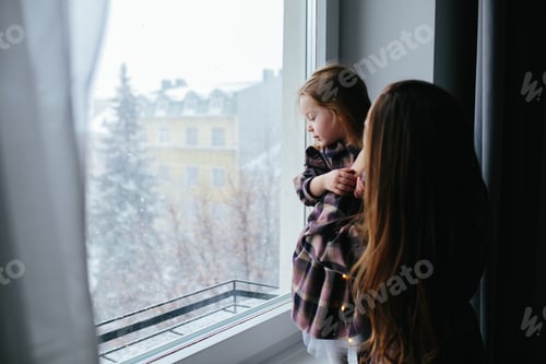 Preview: Mom with little girl looking through the window