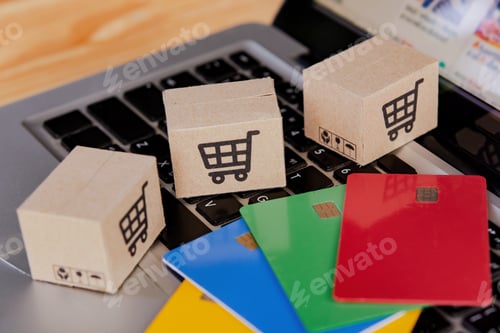 Preview: Credit card and cardboard box with a shopping cart logo on wood table.
