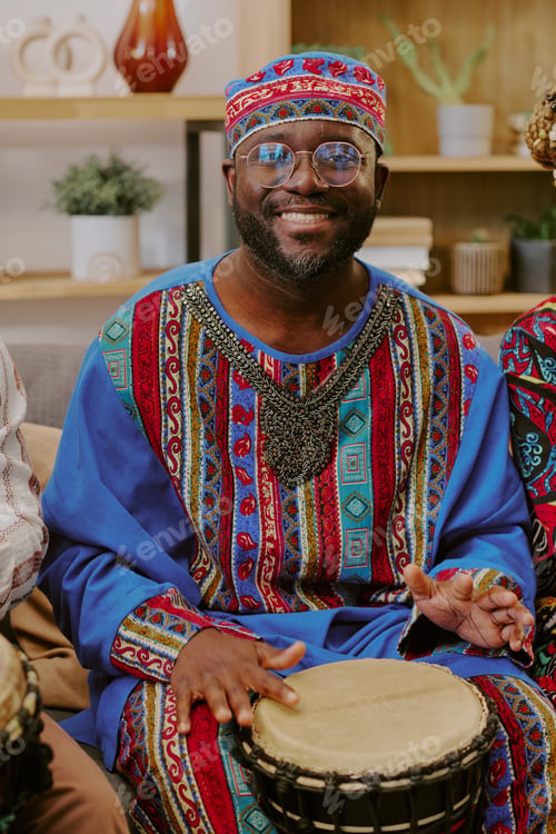 Preview: Portrait of Middle Aged Black Man Celebrating Kwanzaa Playing Drum Smiling