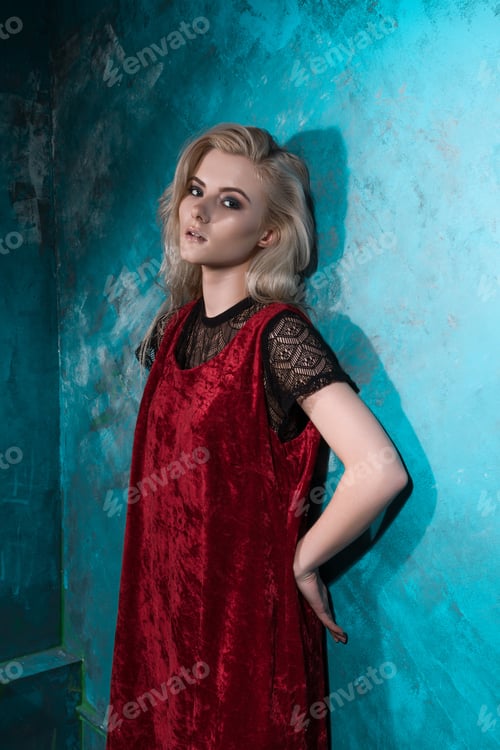 Preview: Beautiful Blonde Girl In A Red Dress Posing Against A Wall Green