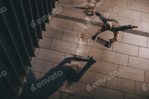 Preview: high angle view of skateboarder in modern streetwear performing jump trick