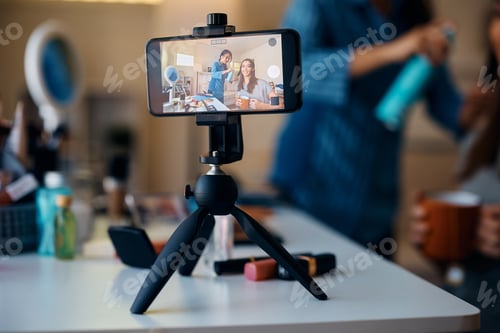 Preview: Close up of young women recording hairstyle vlog with mobile phone.